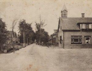 Gezicht op de Kerkweg vanaf de brug in Driebruggen met rechts het gemeentehuis van Lange Ruige Weide, 1925-1935 (fotonummer D0108).